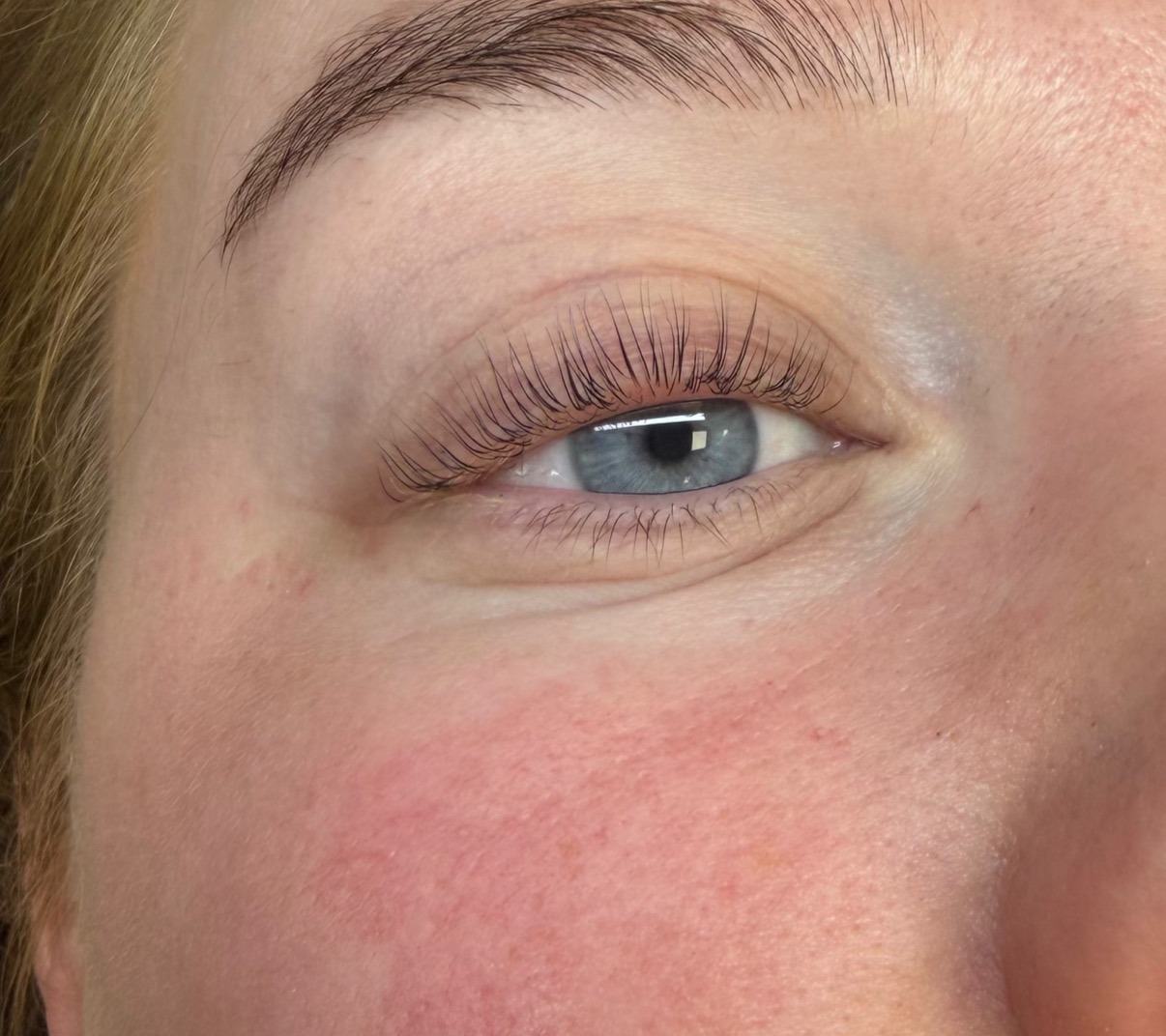 Hetzelfde oog na de lashlift, met gelifte, donkere wimpers