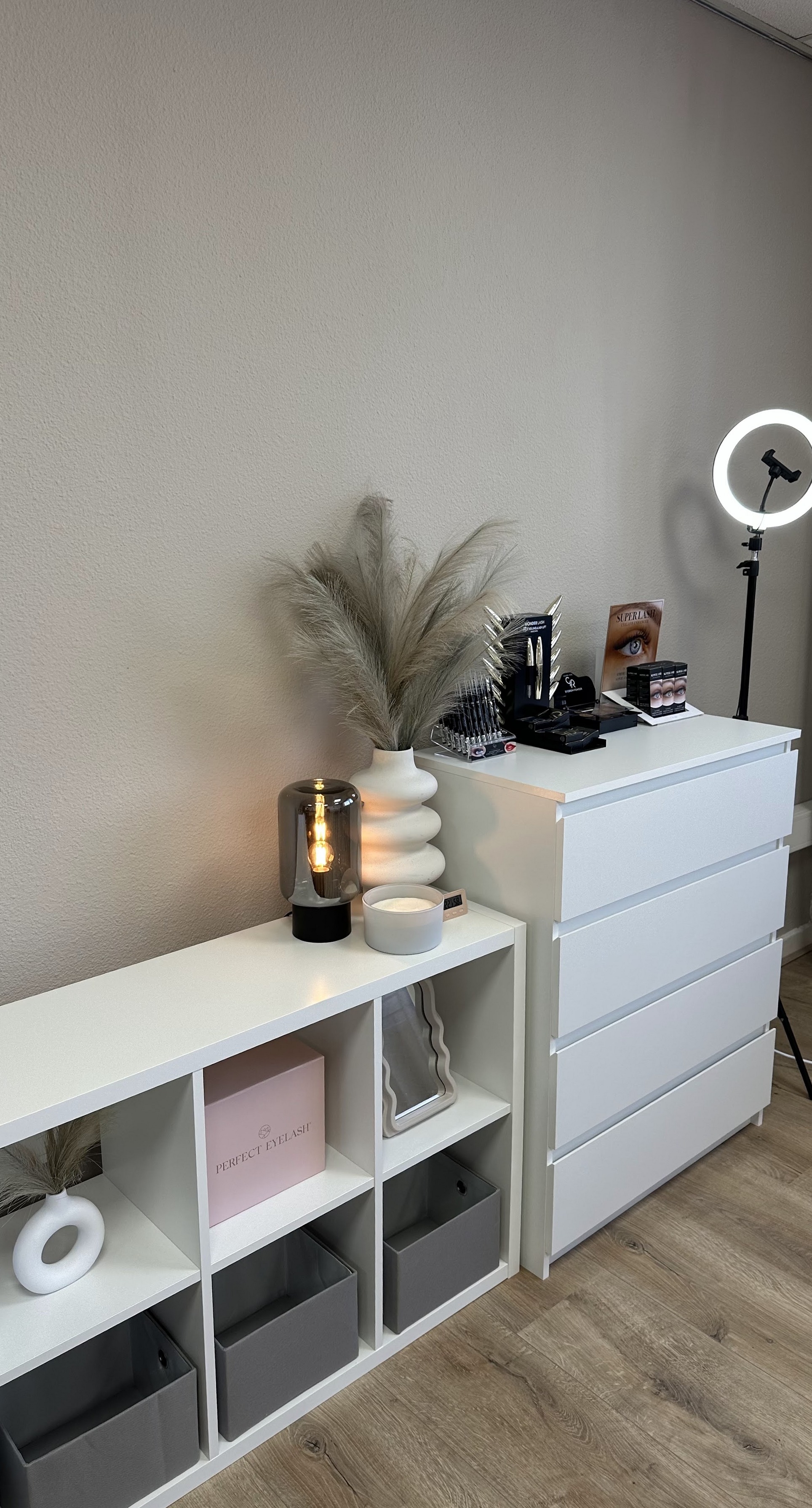 Witte kasten met producten, pampasgras en een ringlamp